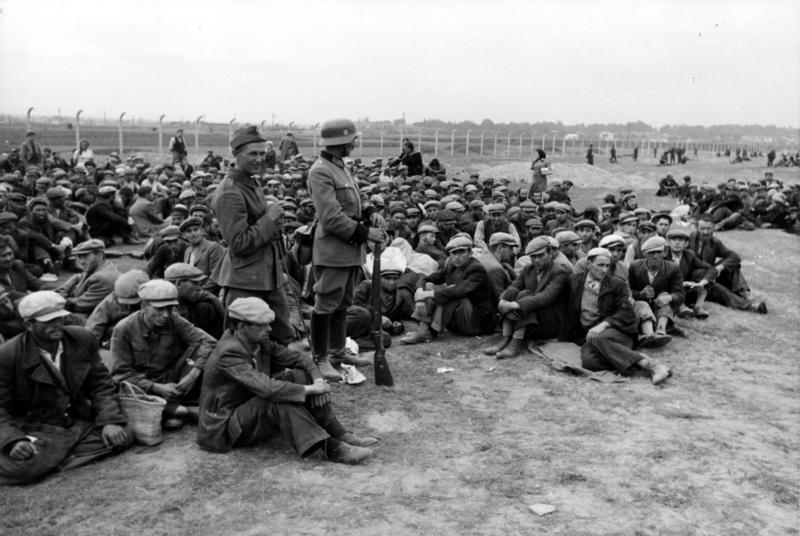 Jewish detainees gathered behind barbed wire in Kraków, Poland, December 1939, shortly after the German occupation.
